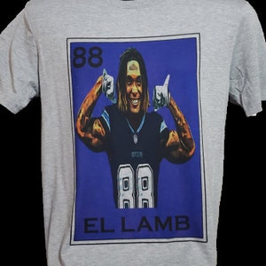 May include: A gray t-shirt with a blue and white graphic of a football player with the number 88 on his jersey. The graphic is in the style of a Loteria card and says "EL LAMB" at the bottom.
