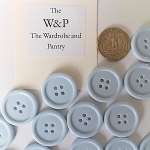 Juego de 5 botones de plástico azul claro de 24,5 mm (1"), con parte frontal estriada y parte posterior plana.