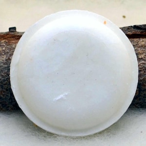 Può includere: Un portasapone rotondo bianco con un bordo leggermente rialzato. Il portasapone è realizzato in un materiale liscio e duro e ha una superficie leggermente testurizzata.