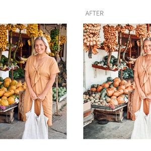 May include: A woman in a light orange dress stands in front of a fruit stand with a variety of fruits and vegetables. She is holding a white tote bag.