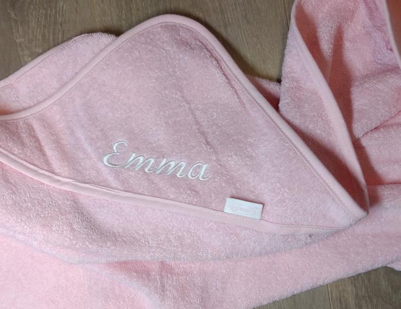 May include: Pink hooded towel with the name "Emma" embroidered on it.
