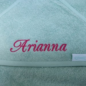 May include: A light green hooded towel with the name "Arianne" embroidered in pink.