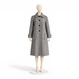 May include: A gray and white herringbone pattern coat with a classic collar, three black buttons, and two front pockets. The coat is displayed on a mannequin against a white background. The coat has long sleeves and a knee-length hem.