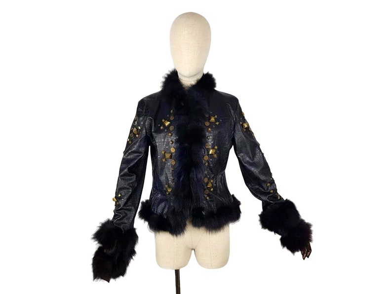 K&ouml;nnte beinhalten: Eine schwarze Lederjacke mit goldenen Nieten und einem schwarzen Pelzkragen und -&auml;rmeln.