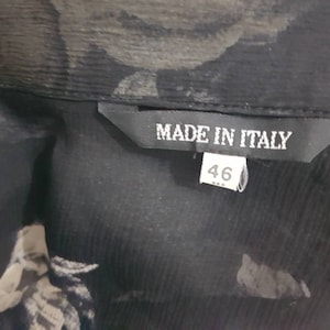 May include: Black sheer blouse with a floral print and a black label that says "Made in Italy" and "46".