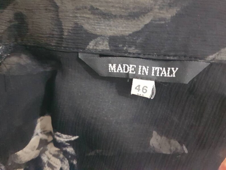 May include: Black sheer blouse with a floral print and a black label that says "Made in Italy" and "46".