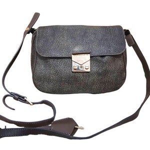 May include: A brown leather crossbody bag with a silver clasp and adjustable strap.