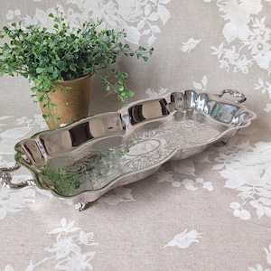 May include: A white ceramic mug with a black handle and the text "But First, Coffee" in a black, bold font. The mug is on a white surface.