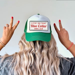May include: A green and white trucker hat with a white patch that says "Livin' on that Blue Collar Dollar" in red and white text.