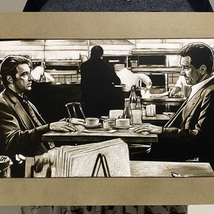 May include: A black and white illustration of two men sitting at a table in a diner. The men are wearing suits and are talking to each other. There are coffee cups and other items on the table.