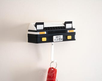 May include: A black and white 3D printed car key holder with a white license plate that reads "#13-954".