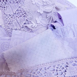 Könnte beinhalten: Nahaufnahme verschiedener Lavendel-Stoffmuster. Das Bild zeigt verschiedene Texturen, darunter Spitze, gepunktete und gemusterte Materialien. Die Stoffe sind geschichtet und zeigen komplizierte Details und eine weiche, pastellfarbene Farbpalette.