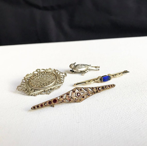 Antique and vintage brooches / bar brooch made of brass / marcasites / silver-colored with breakthrough pattern / little bird