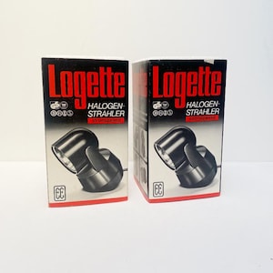 Può includere: Due scatole di faretti alogeni Logette. Le scatole sono nere con testo rosso e presentano un'immagine di un faretto nero. Il testo sulle scatole include "HALOGEN-STRAHLER" e "strømsparend".