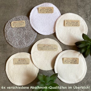 Könnte beinhalten: Sechs verschiedene Arten von wiederverwendbaren Abschminkpads. Die Pads bestehen aus verschiedenen Materialien, darunter Bambus, Baumwolle und Flanell. Die Pads sind mit ihrem Material und ihren Zertifizierungsinformationen gekennzeichnet. Der Text auf den Etiketten lautet: "Bambus-Frottee Dekotex Standard 100, 90% Viskose aus Bambus Zellfaser, 10% Polyester", "Bambus-Frottee Dekotex Standard 100, 70% Viskose Bambus, 30% Baumwolle", "Bio-Flanell 100% Baumwolle aus kontrolliert biologisches Anbau (kb) & GOTS zertifiziert", "BIO-Molton 100% Baumwolle aus kontrolliert biologischer Anbau (kbA)", "Bambus-FleeceFrottee Dekotex Standard 100, 80% Viskose aus Bambus-Zellfaser, 20% Baumwolle", "Bambus-Fleece Dekotex Standard 100, 70% Viskose aus Bambus Zellfaser, 30% Baumwolle".