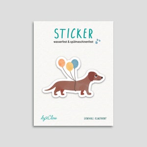 Könnte beinhalten: Ein Sticker mit einem braunen Dackel, an dessen Rücken drei Ballons befestigt sind. Die Ballons sind orange, gelb und blau. Der Sticker trägt den Schriftzug "STICKER" und "wasserfest & spülmaschinenfest". Der Sticker ist von Clou und liebevoll illustriert.