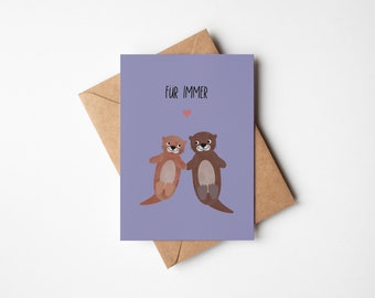 May include: A purple card with two brown otters holding hands. The card says "Für Immer" with a small pink heart above the otters.