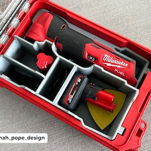 May include: A red Milwaukee FUEL oscillating tool and a red and black Milwaukee FUEL multi-tool are stored in a red hard case with a grey foam insert. The tools are labelled "FUEL" and have a black and red battery.