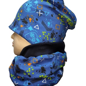 Könnte beinhalten: Ein blaues Mützen- und Halstuch-Set mit einem Gamer-Print mit schwarzen, orangen und grünen Akzenten. Der Druck enthält Gamecontroller, Quadrate, Dreiecke und Kreuze.