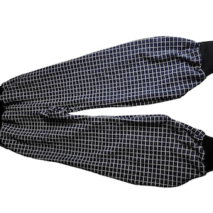 Könnte beinhalten: Marineblaue Hose mit weißem Gittermuster und schwarzen Bündchen. Die Hose hat eine lockere Passform mit einem Gittermuster. Die Bündchen sind aus einem einfarbigen schwarzen Material.