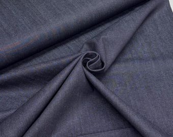 May include: Close-up of a dark blue fabric with a subtle sheen. The fabric is folded and draped, creating soft shadows and highlighting the texture. The material appears to be a medium-weight textile, suitable for apparel or home decor.