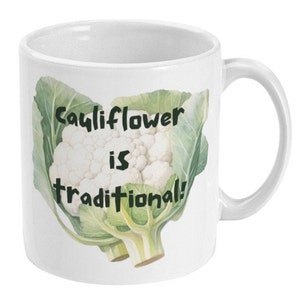 May include: White ceramic mug featuring a green and white cauliflower illustration with the text "Cauliflower is traditional!"