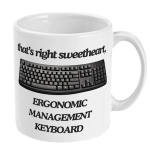 Peut inclure: Une tasse en céramique blanche avec du texte noir qui dit "that's right sweetheart, ERGONOMIC MANAGEMENT KEYBOARD" et un graphique de clavier d'ordinateur noir et gris.