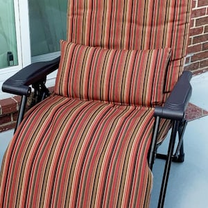 May include: A striped outdoor recliner chair with a matching pillow. The chair features a black frame and armrests. The fabric has vertical stripes in shades of red, brown, and beige. The chair is designed for relaxation.