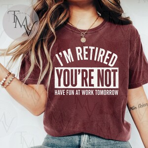 Peut inclure: T-shirt bordeaux avec l'inscription blanche "I'M RETIRED YOU'RE NOT HAVE FUN AT WORK TOMORROW". Le t-shirt a des manches courtes et un col rond.