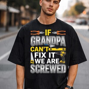 Peut inclure: T-shirt noir avec l'inscription "IF GRANDPA CAN'T FIX IT WE ARE SCREWED" en blanc, orange et jaune. Le motif comprend des illustrations d'outils tels que des pinces, un niveau et une perceuse.