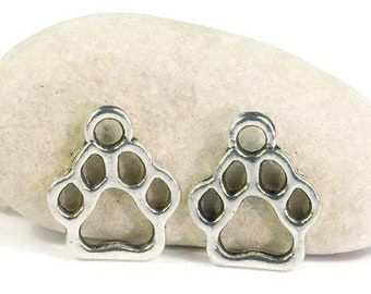 May include: Two silver-toned metal charms shaped like paw prints. The charms are on a white background.