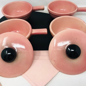 May include: Set of six pink ceramic ramekins with lids. The ramekins have a smooth, glossy finish and are perfect for serving individual portions of soup, dessert, or other dishes.