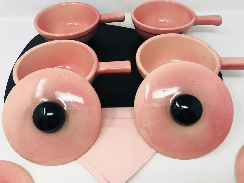 May include: Set of six pink ceramic ramekins with lids. The ramekins have a smooth, glossy finish and are perfect for serving individual portions of soup, dessert, or other dishes.
