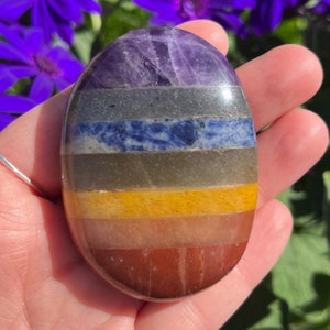 Op de afbeelding: Een zeven chakra handsteen met lagen amethist, rookkwarts, sodaliet, groene aventurijn, citrien, carneol en rode jaspis.
