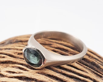 White gold ring with blue/green sapphire