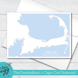 May include: A light blue notecard with a white outline of Cape Cod, Massachusetts, USA. The text "Cape Cod" and "Massachusetts, USA" is printed in black.