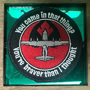 May include: A black and red embroidered patch with a white airplane and the text "You came in that thing? You're braver than I thought."