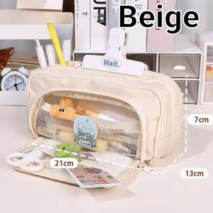 May include: A beige pencil case with a zipper closure, featuring a white clip labeled "Wait." on top. The interior has mesh pockets containing stationery items. Dimensions are clearly marked as 21cm in length, 7cm in height, and 13cm in width.