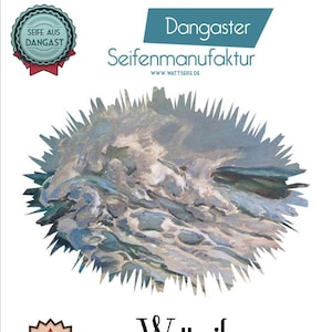 May include: A blue and white illustration of a seascape with the text "Dangaster Seifenmanufaktur WWW.WATTSEIFE.DE" above it. Below the illustration is the text "Wattseife Mit Dangaster Sole-Wasser Made aus DANGAST".