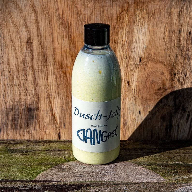 Puede incluir: Una botella de pl&aacute;stico transparente con tapa negra llena de un l&iacute;quido amarillo. La botella tiene una etiqueta blanca con el texto "Dusch-Jelly Das Original von BANGAST" impreso en ella.
