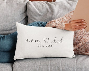 May include: White throw pillow with the text "mom ♥ dad est. 2021" in black cursive font.