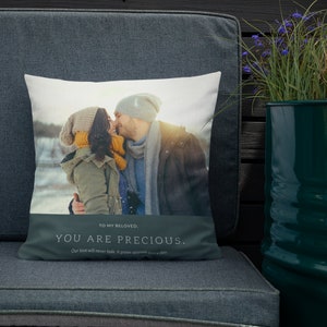 May include: A decorative pillow featuring a photograph of a couple kissing in a winter setting. The pillow has a dark teal band at the bottom with the text "TO MY BELOVED. YOU ARE PRECIOUS. Our love will never fade. It grows stronger every day."