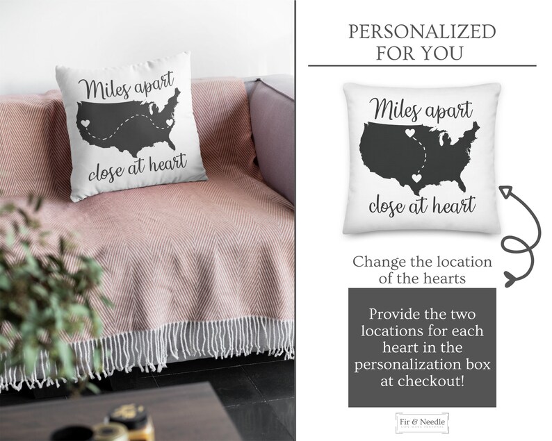 May include: White square pillow with a black silhouette of the United States, two heart icons, and the text "Miles apart close at heart." The pillow is on a pink blanket.