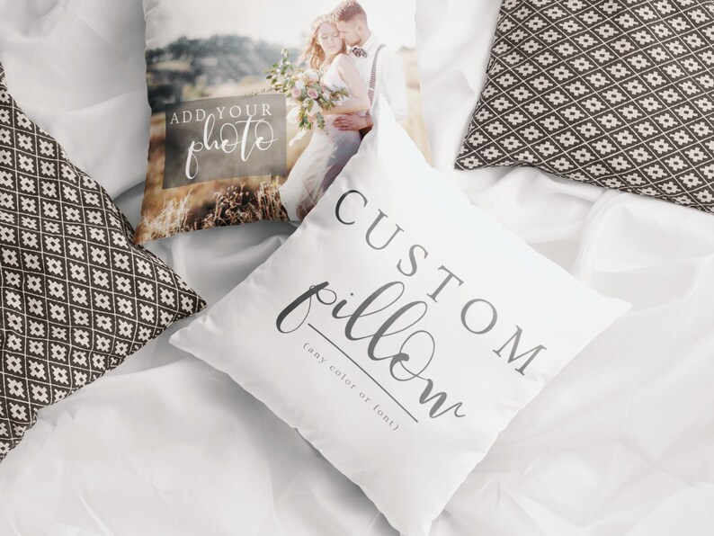 May include: White custom pillow with the text "CUSTOM pillow" in gray script. Another pillow displays a photo of a couple. Two additional pillows with a black and white geometric pattern are also visible.