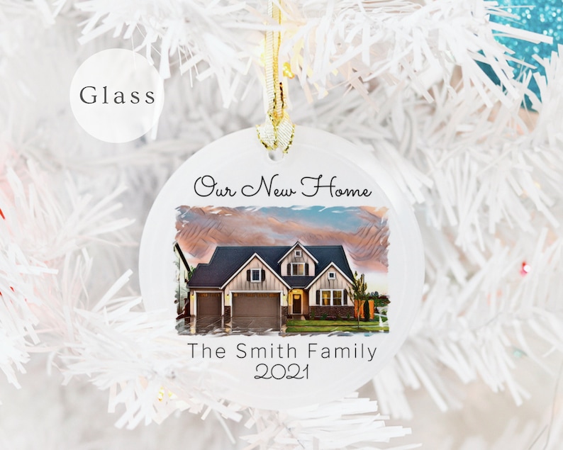 May include: White round glass ornament with a picture of a house and the text "Our New Home The Smith Family 2021".