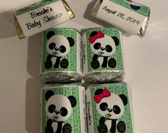 May include: Four small wrapped chocolate favors with panda bear designs and green bamboo backgrounds. The wrappers have text that says "Brooke's Baby Shower" and "August 28, 2019".