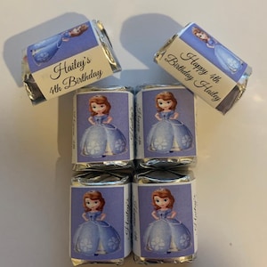 May include: Six small silver foil-wrapped chocolate bars with a princess character and a personalized birthday message. The message on the top bar reads "Happy 4th Birthday Hailey". The message on the bottom bar reads "Hailey's 4th Birthday".