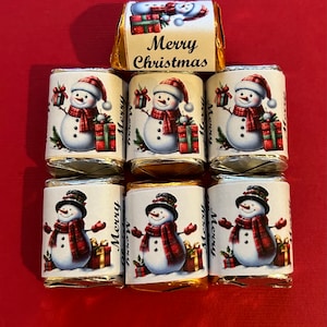 May include: Six small wrapped chocolate bars with snowman designs and "Merry Christmas" text on the wrappers. The wrappers are gold and white with red accents.