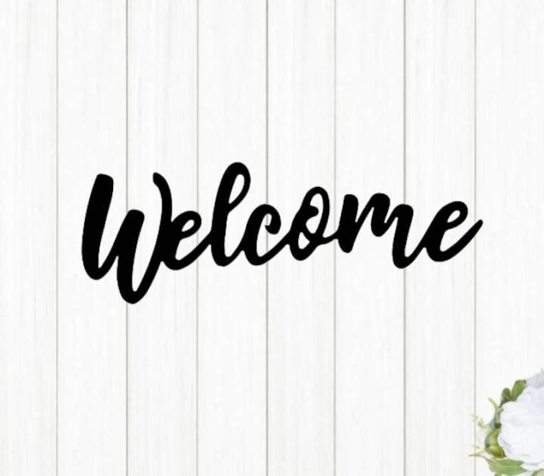 May include: Black cursive script lettering that reads "Welcome" on a white wood background.