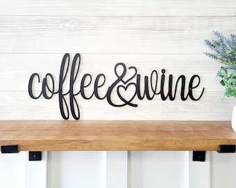 May include: Black metal wall decor with the words "coffee & wine" in a cursive font.